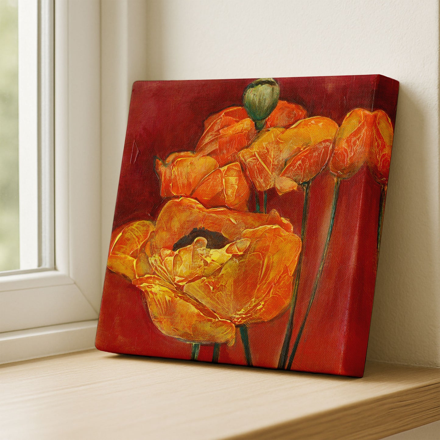 Canvas print of orange flowers on a red background, leaning against a wall.
