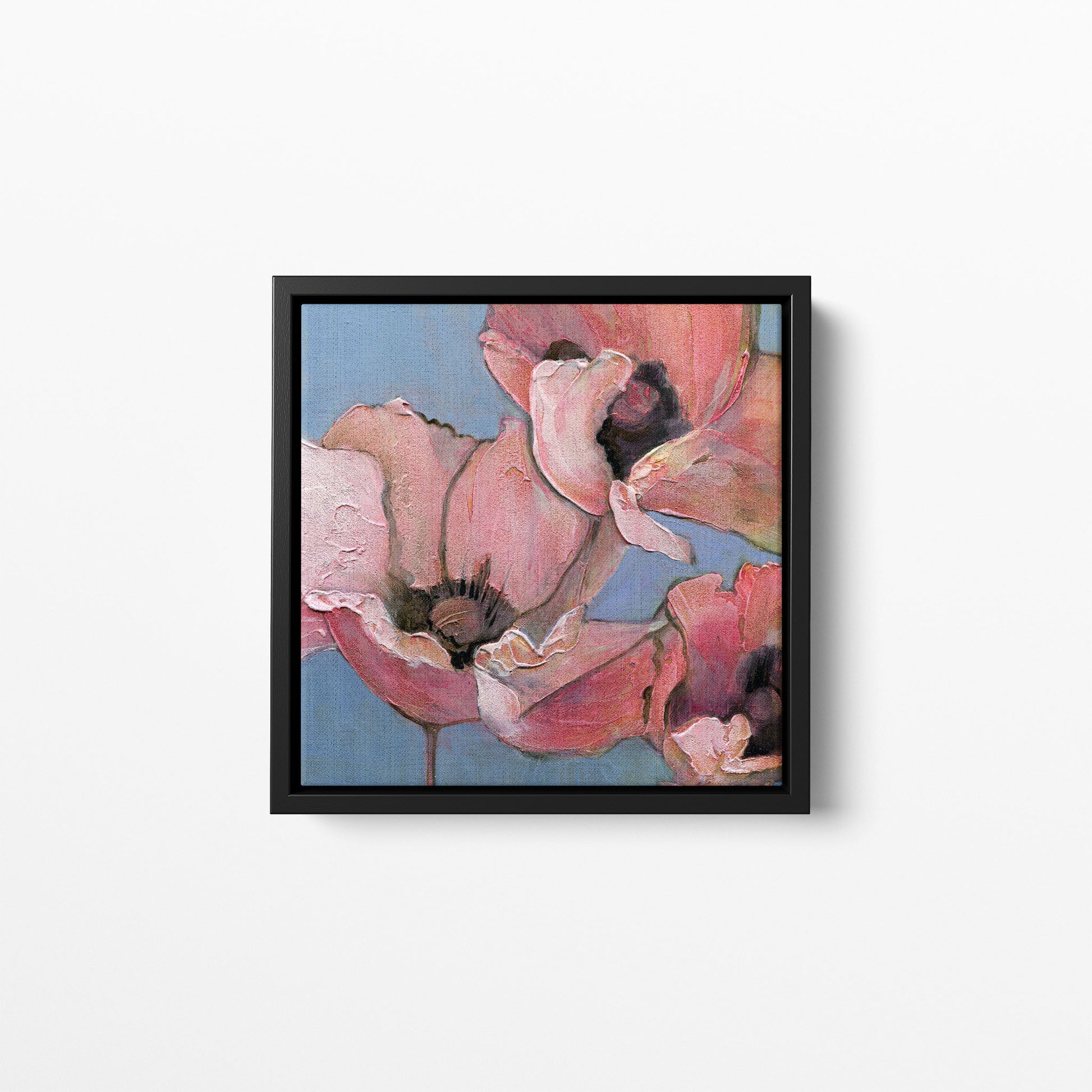 A 12x12 inch print of an acrylic painting of poppies in shades of pink, peach, and blue. Framed in a black frame.