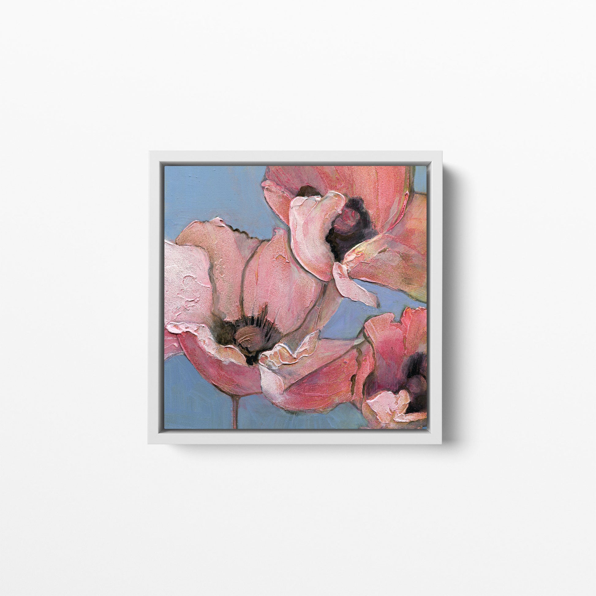 A 12x12 inch print of an acrylic painting of poppies in shades of pink, peach, and blue. Framed in a white frame.
